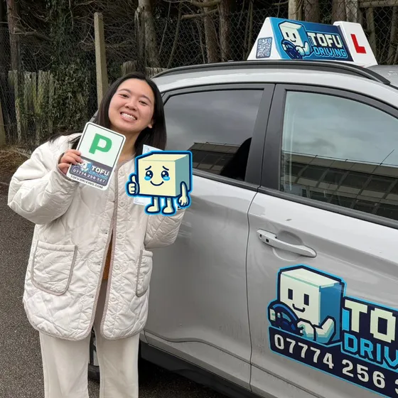 Wing - A TOFU Driving student celebrating passing the driving test next to the instructor's car