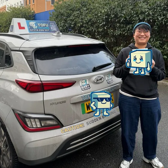 Caylus - A TOFU Driving student celebrating passing the driving test next to the instructor's car